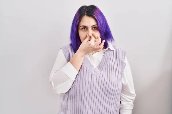 さらにサイズの女性は 白い背景の上に立っている紫色の髪は 臭いと嫌な 耐え難い匂いを嗅ぎ 鼻に指で息を止めます 悪い匂いがする — ストック写真