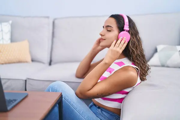年轻美丽的惊慌失措的女人坐在家里的沙发上听音乐 — 图库照片