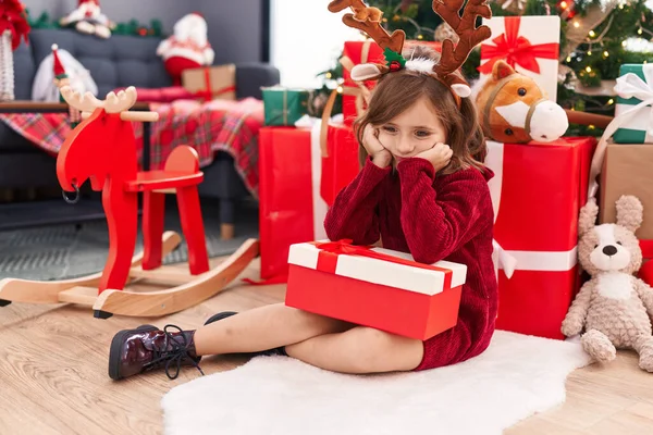 크리스마스 바닥에 앉아서 집에서 표정으로 선물을 스페인 — 스톡 사진