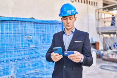 Akıllı telefon ve kredi kartı kullanan genç bir mimar.