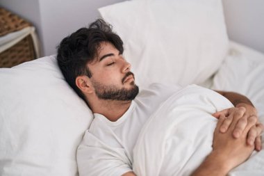 Genç İspanyol adam yatakta uzanıp yatak odasında uyuyor.