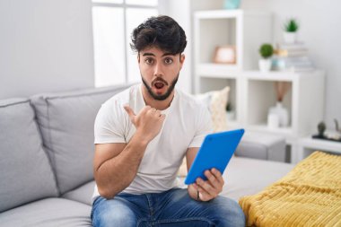 Kanepede oturan dokunmatik sakallı İspanyol bir adam el ile işaret ederek şaşırdı, ağzı açık şaşkın bir ifade.. 