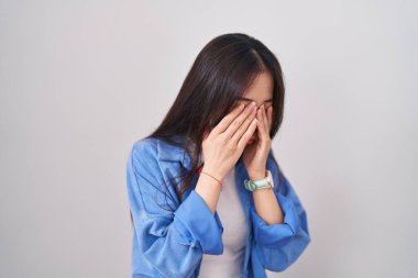 Beyaz arka planda duran genç Çinli kadın yorgunluk ve baş ağrısı için gözlerini ovuşturuyor, uykulu ve yorgun ifade. görme sorunu 