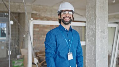 Şantiyede kendine gülen genç İspanyol mimar.