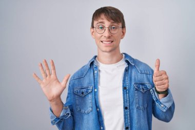Beyaz, sarışın, gözlüklü, 6 numaralı parmaklarıyla işaret eden, kendine güvenen ve mutlu bir adam.. 