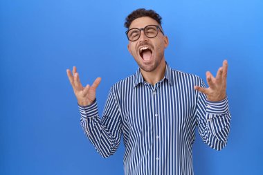 Gözlüklü İspanyol bir adam başarı için deli ve çılgın kutlamalar yapıyor kollarını kaldırmış, gözlerini kapatmış heyecanlı çığlıklar atıyor. Kazanan konsept 