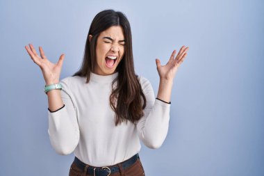 Mavi arka planda duran genç esmer kadın başarının çılgınlığını kollarını kaldırmış ve gözlerini kapatmış heyecanla haykırarak kutluyor. Kazanan konsept 