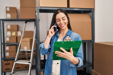 Genç, güzel, İspanyol bir kadın. İşadamı, ofisteki akıllı telefon okuma belgeleriyle konuşuyor.