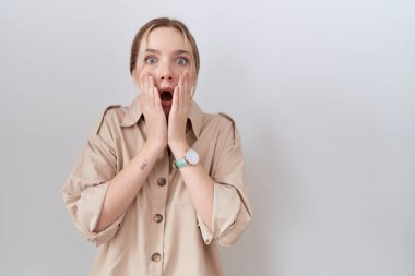 Yüzünde elleri olan, korkmuş ve şok olmuş, şaşırmış ve şaşırmış genç beyaz bir kadın. 