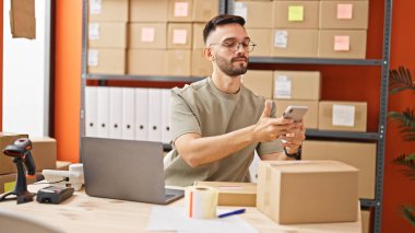 Genç İspanyol adam ecommerce iş adamı ofiste tarama paketi