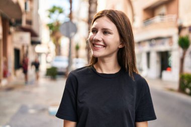 Young blonde woman smiling confident looking to the side at street