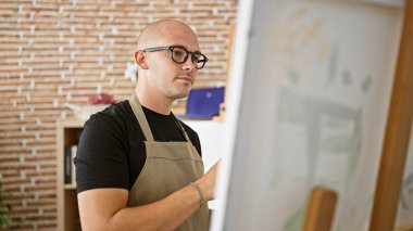 Sanat stüdyosunda resim çizen genç bir İspanyol.