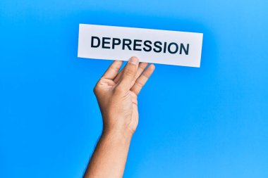 Hand of caucasian man holding paper with depression word over isolated blue background