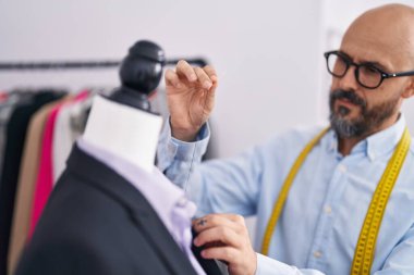 Terzide çalışan kel bir terzi.