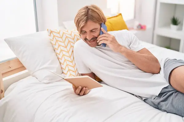 Junger Blonder Mann Spricht Schlafzimmer Mit Smartphone Lesebuch — Stockfoto