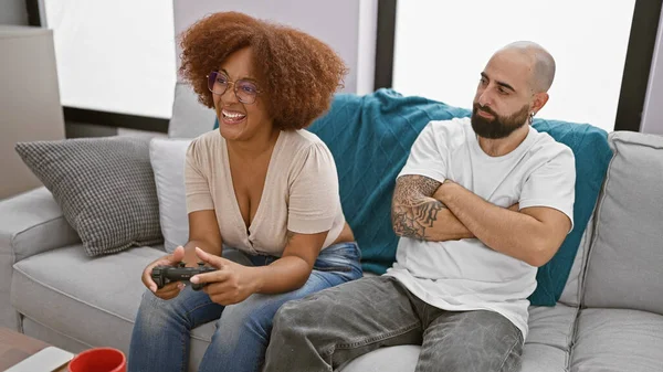 stock image Beautiful interracial couple, looking upset, sit together at home playing video game - love connection tested in living room!