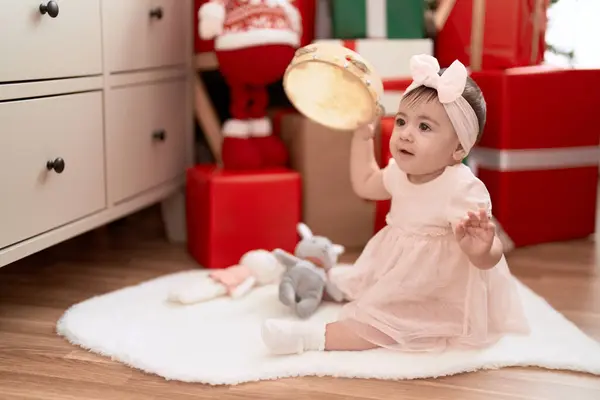 可爱的幼儿在家里靠圣诞礼物坐在地板上打鼓 — 图库照片