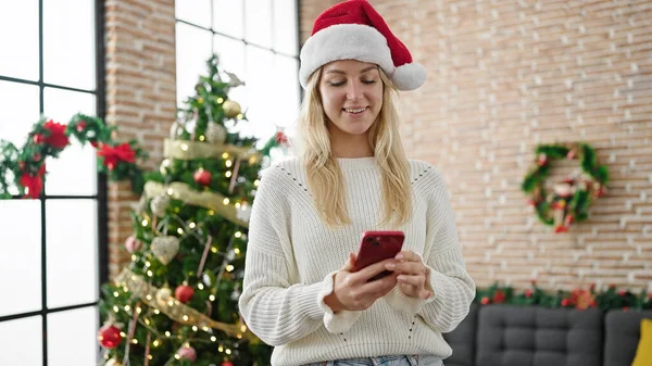 Νεαρή Ξανθιά Γυναίκα Γιορτάζει Χριστούγεννα Χρησιμοποιώντας Smartphone Στο Σπίτι — Φωτογραφία Αρχείου