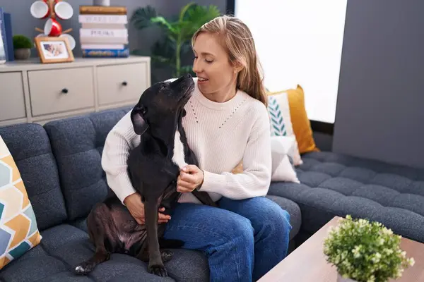 Young Blonde Woman Hugging Dog Sitting Sofa Home — kuvapankkivalokuva