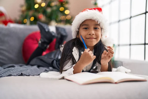 Adorable Hispanic Girl Smiling Confident Lying Sofa Christmas Tree Home — Fotografia de Stock