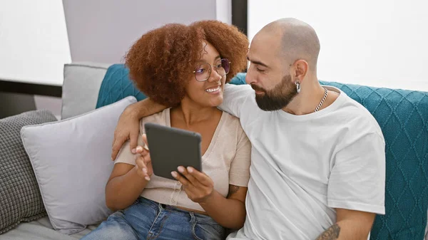 自宅で一緒に座っている美しい笑顔のカップルは 自信を持ってタッチパッド上のオンラインボンディングを楽しんで 彼らの素敵な屋内リビングルームの関係に喜びを放射します — ストック写真