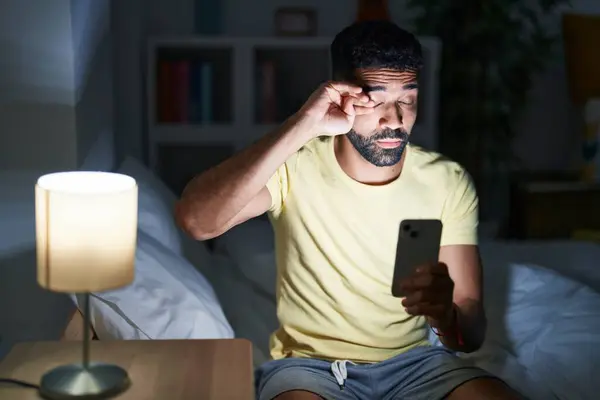 Nuori Arabi Mies Käyttää Älypuhelin Haukottelu Makuuhuoneessa — kuvapankkivalokuva