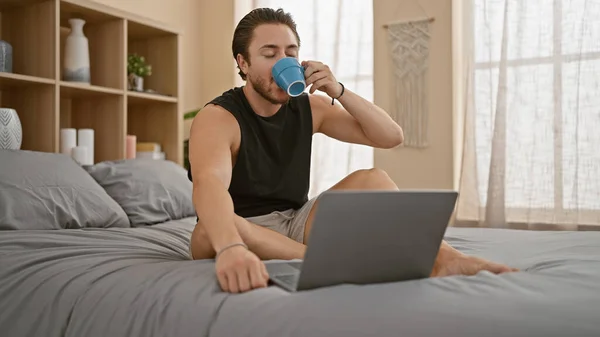 Ung Latinamerikan Man Använder Laptop Dricka Kaffe Sovrummet — Stockfoto