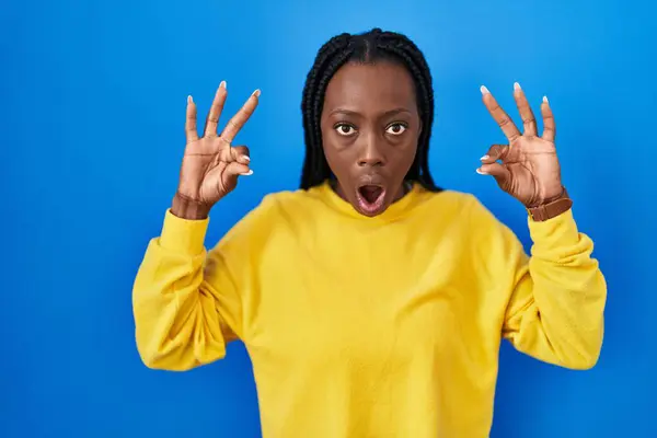 Beautiful Black Woman Standing Blue Background Looking Surprised Shocked Doing — Stock Photo, Image