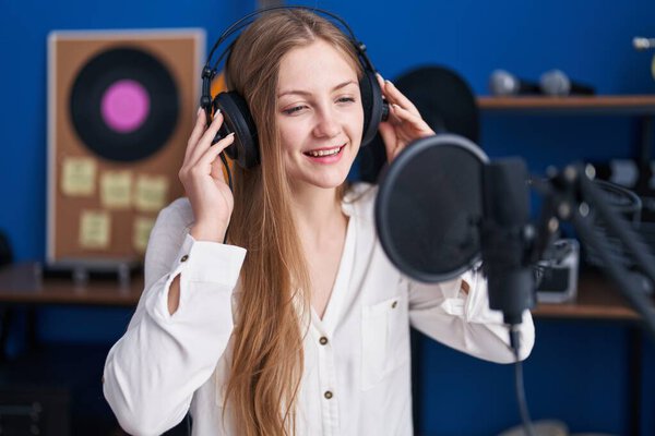 Young caucasian woman artist singing song at music studio