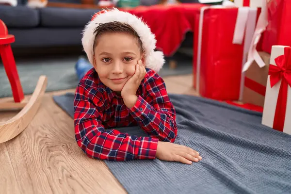 自宅でクリスマスプレゼントで床に横たわって自信を持って微笑む愛らしいヒスパニックの少年 — ストック写真