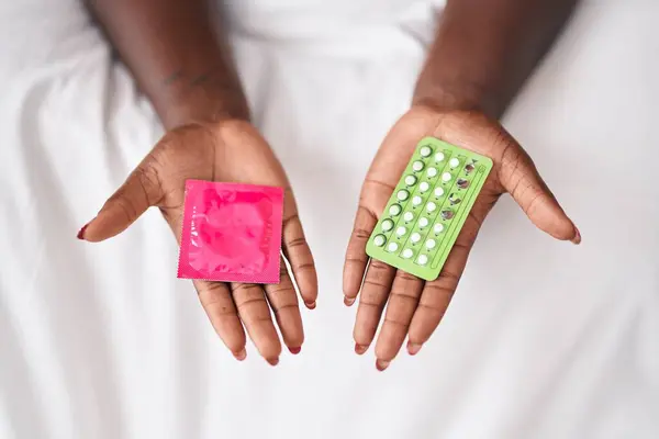Afroamerikanerin Hält Kondom Und Antibabypillen Schlafzimmer — Stockfoto