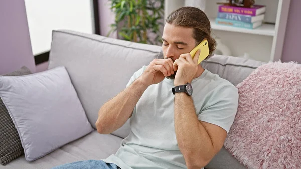 Jovem Hispânico Falando Telefone Sentado Sofá Bocejando Casa — Fotografia de Stock