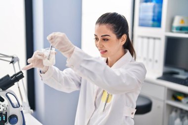 Genç ve güzel İspanyol bilim adamı. Laboratuvarda kendine güvenen bir karışım örneği.