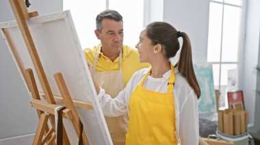 Gülümseyen erkek ve kadın sanatçılar samimi sanat stüdyosunda birlikte çizim yapmaktan hoşlanırlar.