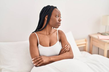 Afrika kökenli Amerikalı kadın, yatakta otururken stresli.