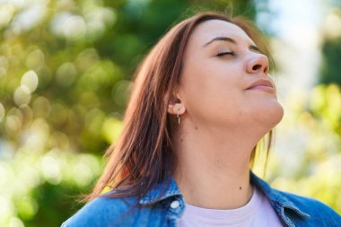 Genç, güzel, iri yarı bir kadın. Parkta gözleri kapalı nefes alıyor.