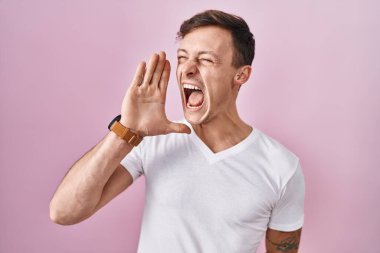 Pembe arka planda duran beyaz bir adam el ele tutuşarak bağırıyor ve çığlık atıyordu. iletişim konsepti. 