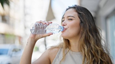 Sokağın ortasında su içen genç, güzel İspanyol kadın.