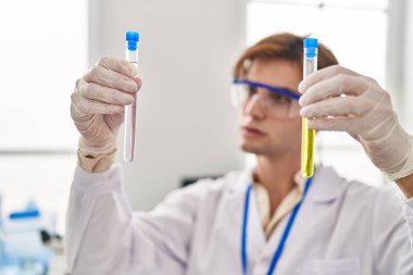 Kafkasyalı genç bilim adamı laboratuarda test tüpleri tutuyor.