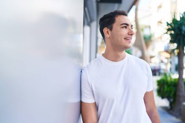 Sokakta kendinden emin gülümseyen İspanyol genç adam.