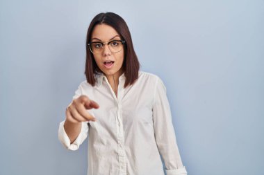 Young hispanic woman standing over white background pointing displeased and frustrated to the camera, angry and furious with you 