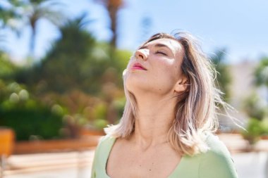Young woman breathing at park
