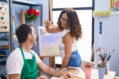 Man and woman artists smiling confident drawing at art studio
