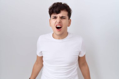 Gündelik beyaz t-shirt giyen genç, sinirli ve kızgın çığlık atan sinirli, öfkeyle bağıran bir adam. öfke ve agresif konsept. 