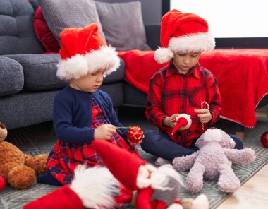 Sevimli erkek ve kız Noel 'i evde şeker ve süs balosu düzenleyerek kutluyorlar.