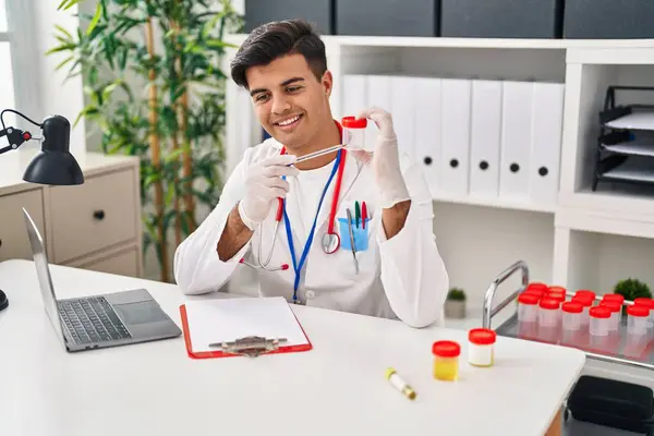 Young Hispanic Man Doctor Writing Medical Report Holding Urine Test — Stock Photo, Image