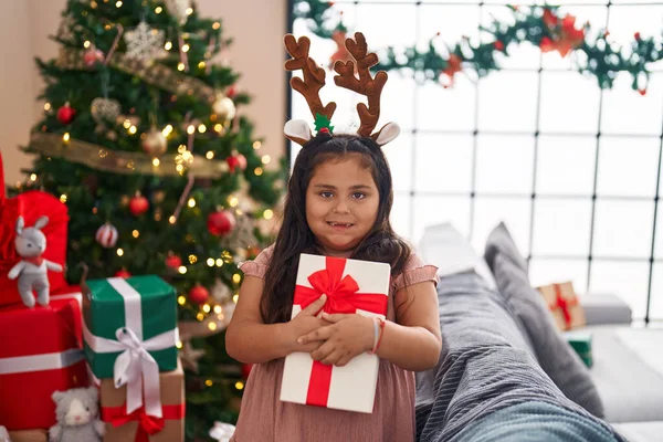 Size Hispanic Girl Hugging Gift Standing Christmas Tree Home — Foto de Stock