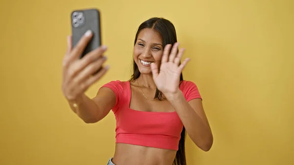 年轻的拉丁女人带着自信微笑 在孤立的黄色背景上打了一个视频电话 — 图库照片