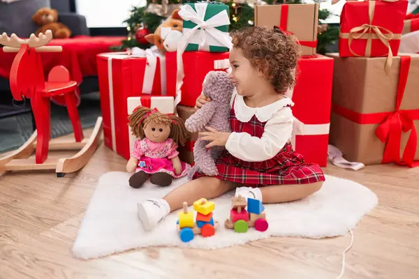 Uroczy Latynoski Maluch Przytulający Pluszowego Misia Siedzącego Podłodze Świątecznymi Prezentami — Zdjęcie stockowe