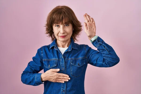 Middle Age Woman Standing Pink Background Swearing Hand Chest Open — Stock Photo, Image